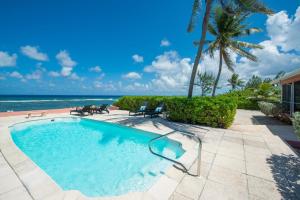 a swimming pool with a view of the ocean at Cayman Dream by Grand Cayman Villas & Condos in Driftwood Village