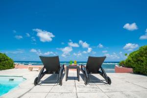 a table and two chairs next to the beach at Cayman Dream by Grand Cayman Villas & Condos in Driftwood Village