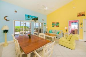 a dining room and living room with a table and chairs at Cayman Dream by Grand Cayman Villas & Condos in Driftwood Village