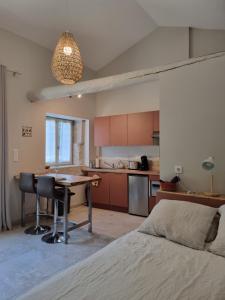 sypialnia z łóżkiem oraz kuchnia ze stołem w obiekcie Le Mazet, gîte des Lucioles en Provence w mieście Montségur-sur-Lauzon