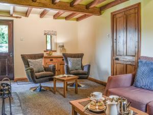 a living room with chairs and a table at Ladycroft Cottage in Hebden