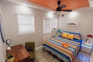 a bedroom with a bed and a table and a ceiling fan at Itz a Vibe - 1 bedroom studio in the heart of DTSP in St. Petersburg