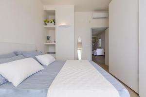 a bedroom with a large bed with white and blue sheets at L'Attico di Alessia by BarbarHouse in Maruggio