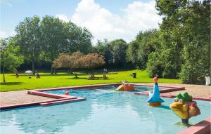 a swimming pool in a park with people in the grass at Beautiful Home In Heinkenszand With Wifi in Heinkensand