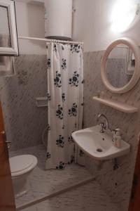 a bathroom with a shower curtain and a sink at Viki Studios in Pefki