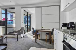- une cuisine avec une table et des chaises dans la chambre dans l'établissement Gorgeous Cityscape Apartment in Auckland's CBD, à Auckland