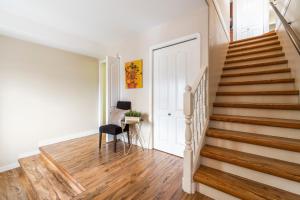 a staircase in a home with white walls and wooden floors at Lake View Hideaway in Vernon