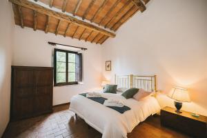 een slaapkamer met een groot bed en een raam bij Podere Lupinati in Panzano