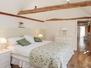 - une chambre avec un lit blanc et des oreillers verts dans l'établissement Oast Cottage, à Maidstone