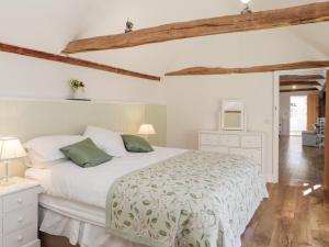 a bedroom with a white bed with green pillows at Oast Cottage in Maidstone