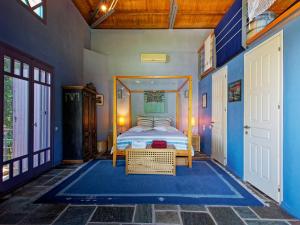 a bedroom with a bed and a blue wall at Tsagkarada Country Estate with Pool in Tsagarada