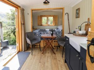 a kitchen with a table and chairs in a caravan at Llethr - Shepherds Hut in Llanbedr