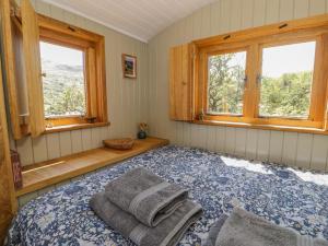 a bedroom with a bed with two towels on it at Llethr - Shepherds Hut in Llanbedr