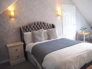 een slaapkamer met een groot bed met witte lakens en kussens bij Willow Brook in Glossop