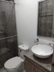 y baño con aseo, lavabo y ducha. en Apartamento 302 Yopal, en Yopal
