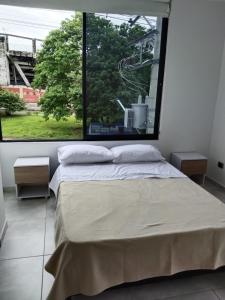 a bed in a room with a large window at Apartamento 302 Yopal in Yopal