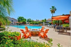 a pool with chairs and a table and an umbrella at Luxury Tempe Apt by ASU & Airport in Phoenix