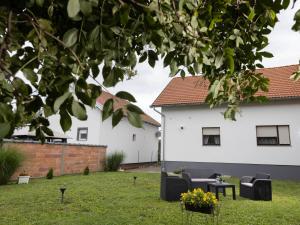 a yard with two white houses and some flowers at Vacation home Ivana in Vukovar