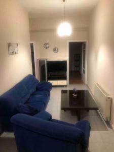 a living room with a blue couch and a table at Apartment MCS in Igoumenitsa