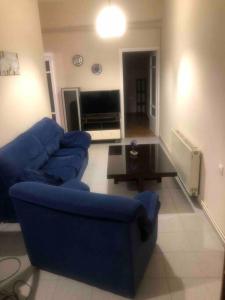 a living room with a blue couch and a table at Apartment MCS in Igoumenitsa