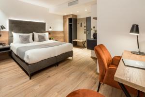 een hotelkamer met een groot bed en een bureau bij Landhotel Sonne in Neuendettelsau