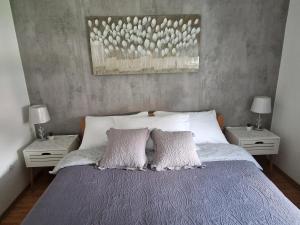 a bed with two white pillows and two tables at Vacation home Ivana in Vukovar