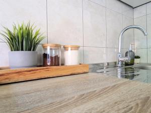 a kitchen counter with three jars on a cutting board at Vacation home Ivana in Vukovar +35 photos