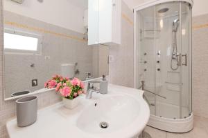 baño con lavabo y ducha con flores rosas en Casa Marconi, en Matino