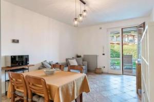 a dining room with a table and a couch at Relax by the pool - Garden - Garage in Polpenazze del Garda