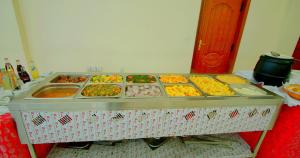 un buffet de diferentes tipos de comida en bandejas en Fatima Hotel, en Ruhengeri