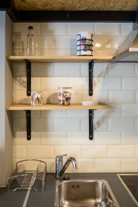 a kitchen with wooden shelves above a sink at Loft 1 in Kos Town