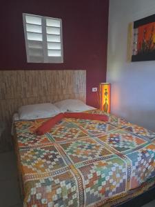 a bed in a bedroom with a quilt on it at A Toca do Bem-Te-Vi in Águas Belas