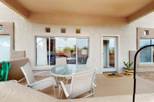 une salle à manger avec une table en verre et des chaises blanches dans l'établissement Vistoso Resort Casita #105, à Oro Valley