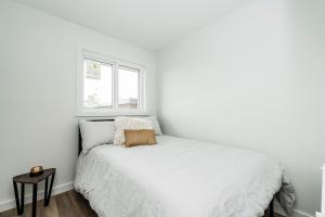 a white bedroom with a bed and a window at RNDup Urban Lofts in Clairmont