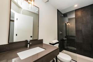 a bathroom with a sink and a toilet and a mirror at RNDup Urban Lofts in Clairmont