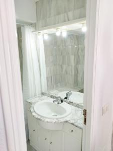 a white bathroom with a sink and a mirror at Embrujo de Mojácar in Mojácar