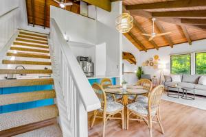 a dining room and living room with a table and chairs at Kahala 924 in Koloa