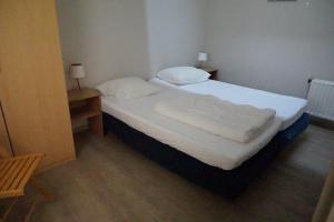 a bedroom with a bed with two pillows on it at Kustverhuur, Oude manege Nieuwvliet, Nieuwvliet 10 in Nieuwvliet