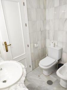 a white bathroom with a toilet and a sink at Embrujo de Mojácar in Mojácar