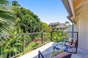 a balcony with chairs and a fence with plants at Kahala 924 in Koloa