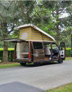 ein Van mit einem Wohnmobil am Straßenrand in der Unterkunft RETRO CAMPER HIRE LTD Campervan Hire Company "Travel Throughout Ireland " in Dublin