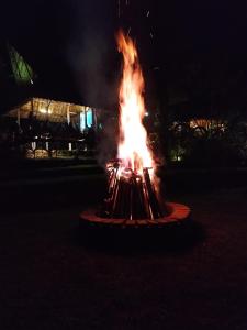 eine Feuerstelle mitten im Garten in der Nacht in der Unterkunft Kebun Hanoman Camping Ground in Pablengan