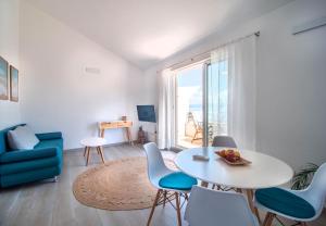 sala de estar con mesa, sillas y ventana en Sunny Apartments, en Stomorska