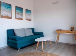 uma sala de estar com um sofá azul e uma mesa em Sunny Apartments em Stomorska