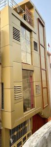 a yellow building with windows and a balcony at Govind Atithi Grah in Ayodhya