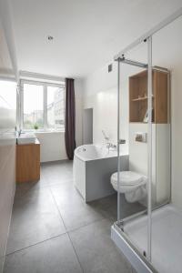 łazienka z wanną, toaletą i umywalką w obiekcie Sleepy3city Apartments 10 Lutego 23 w mieście Gdynia