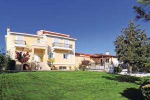 a large house with a lawn in front of it at Crete's Hidden Treasure - Dream Villa with Pool and Majestic Olive Tree Views in Skalánion