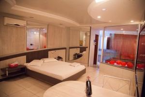 1 dormitorio grande con 1 cama y baño en Motel Kalipso en São José