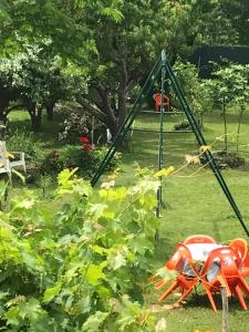 a garden with a swing set in the grass at chambre et salle de bain privé s'ouvrant sur terrasse, jardin et cuisine d'été in Quillan