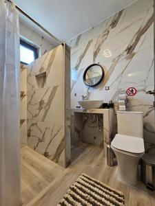 a bathroom with a sink and a toilet and a mirror at Villa Melina in Pefkochori